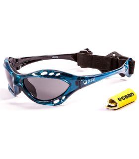 Gafas de sol deportivas Ocean Cumbuco Shiny Blue con montura azul brillante, lentes polarizadas humo y correa.